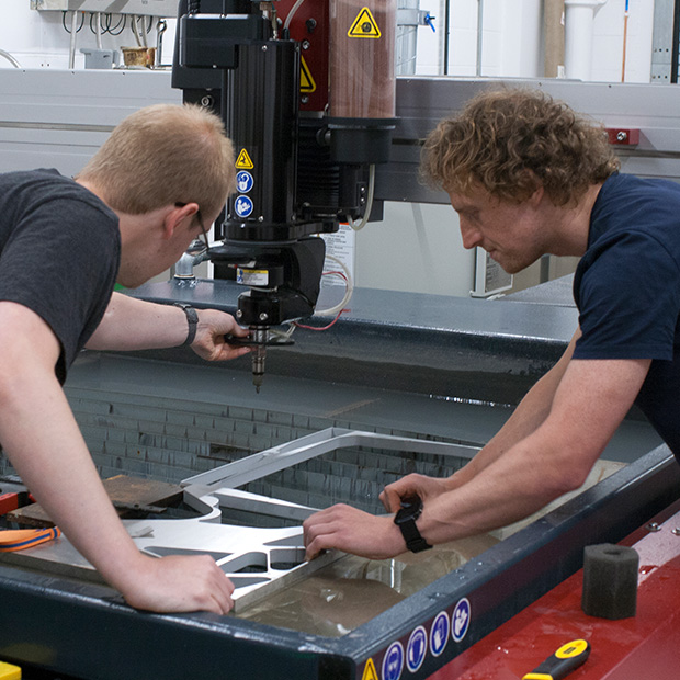 Students working with the water jet cutter the Morson Maker Space, University of Salford