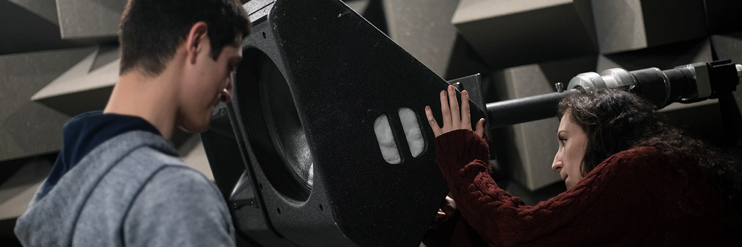 Two students working on equipment in the anechoic chamber, Newton Building, University of Salford
