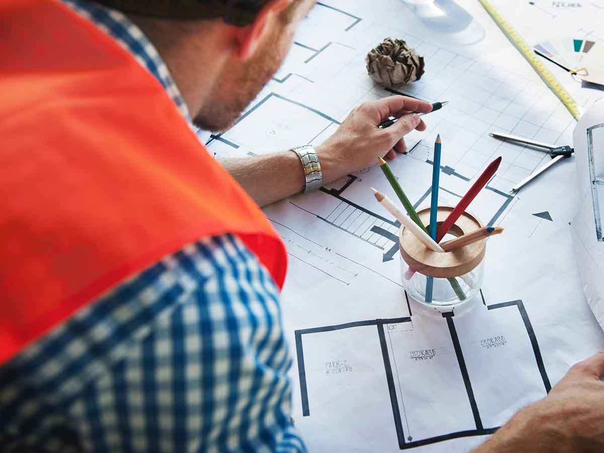 Apprentice reviewing multiple floor plans