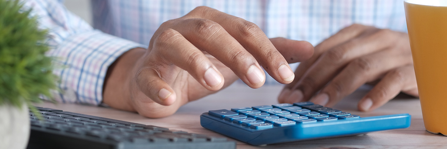 A close-up of a person's hand pressing buttons on a blue calculator