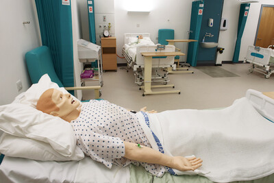 A nursing training doll lying in a hospital bed in the University of Salford’s nursing simulation suite.