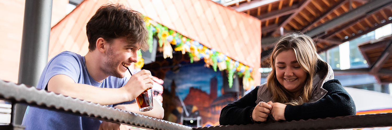 Two students socialising in front of a pop-up vendor stall