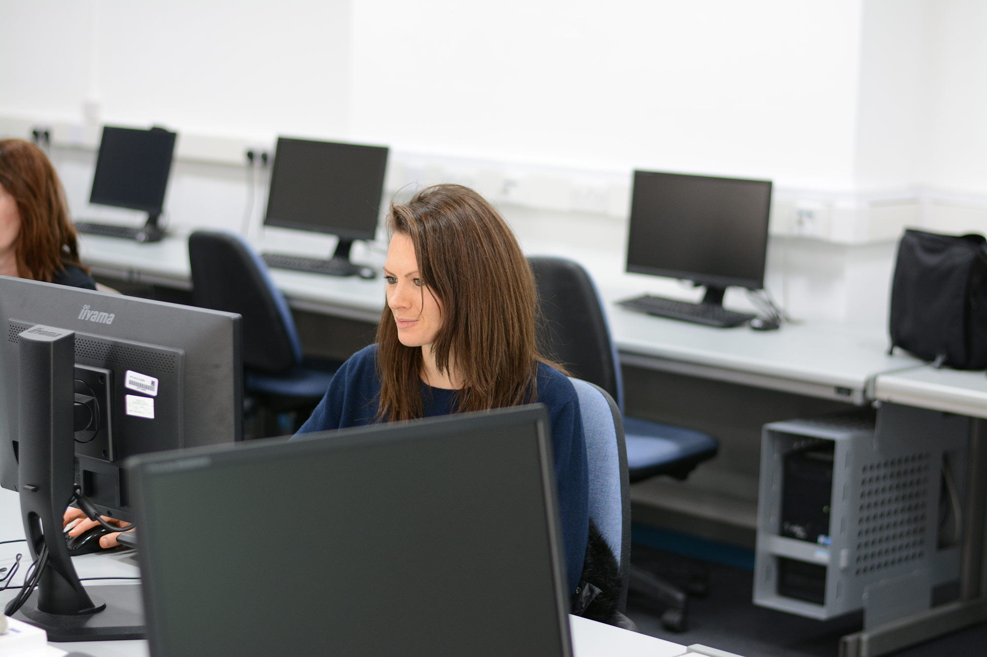 Student working in a library workstation cluster area