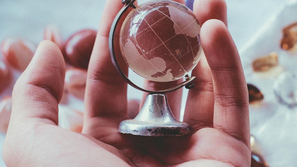 Hand holding a miniature globe