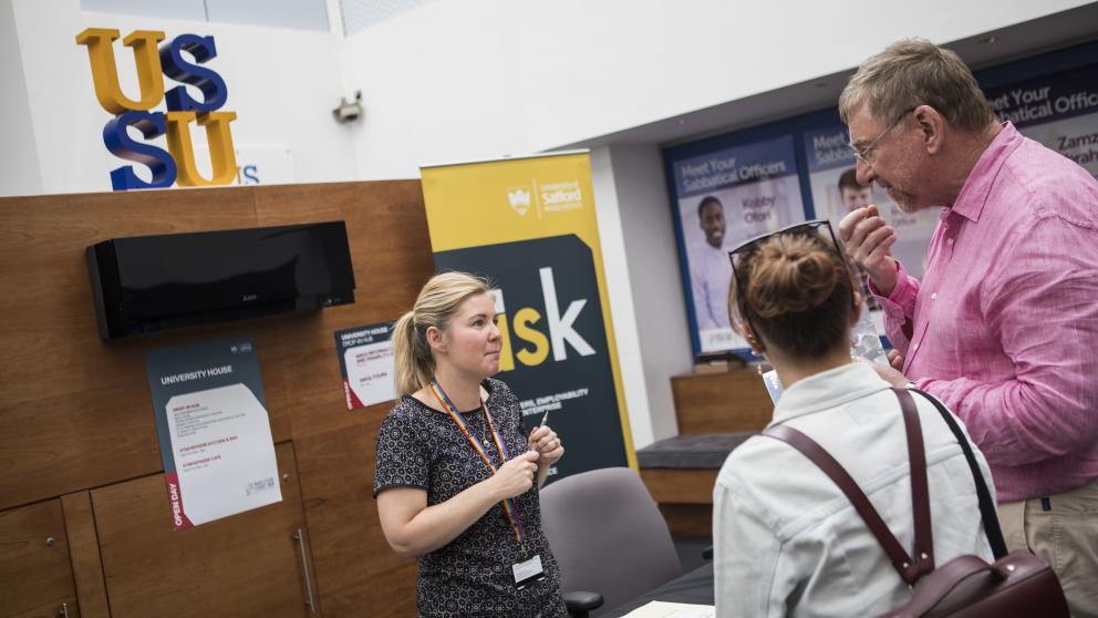 askUs staff member providing advice to two members of the public