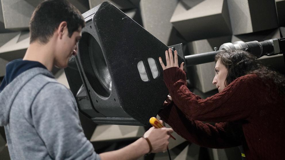 Two students working on equipment in the anechoic chamber, Newton Building, University of Salford