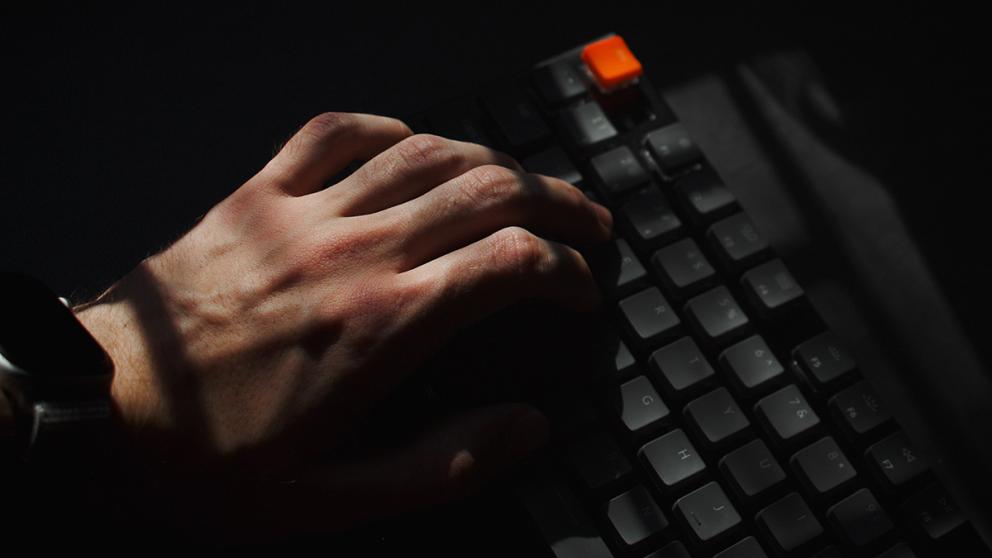 Hand typing on a computer keyboard