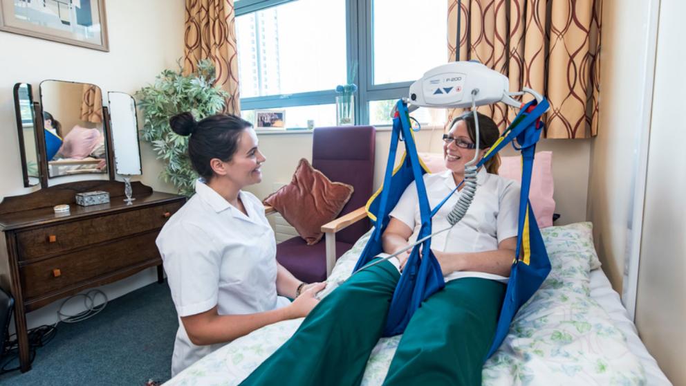 Two colleagues in conversation in an occupational therapy training suite