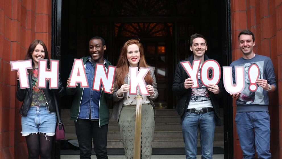 People holding letters that spell the words thank you