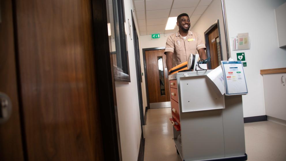Nursing apprentice pushing trolley
