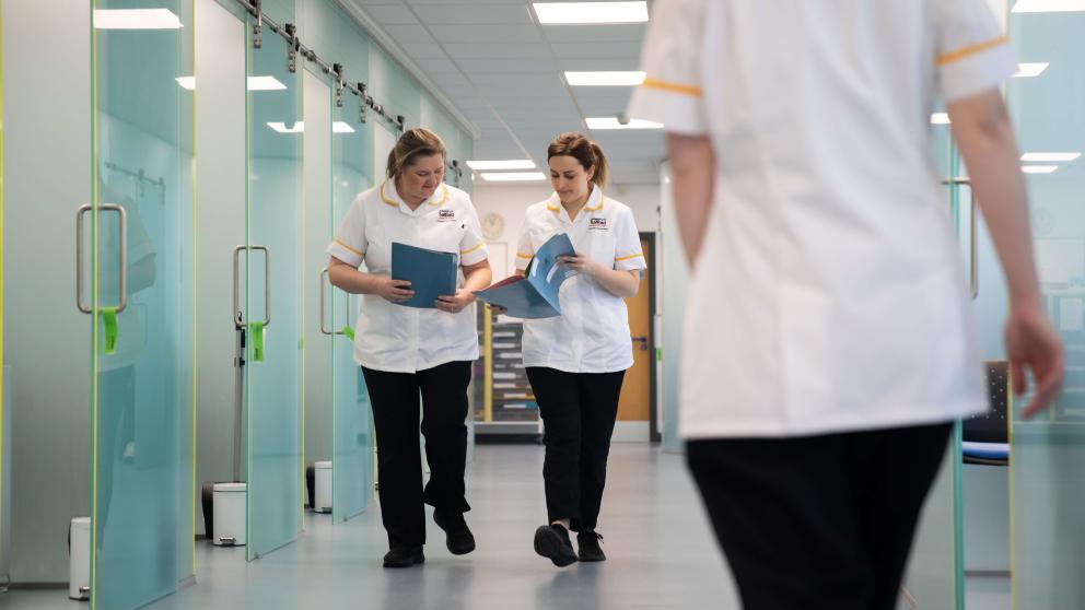 Members of staff walking inside the Podiatry Clinic, University of Salford