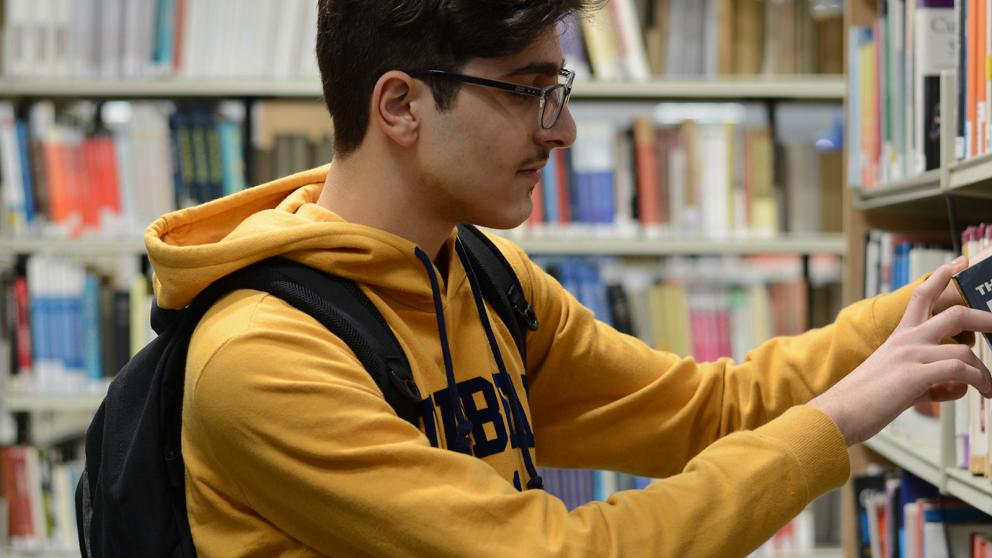 Student searching for books in a library