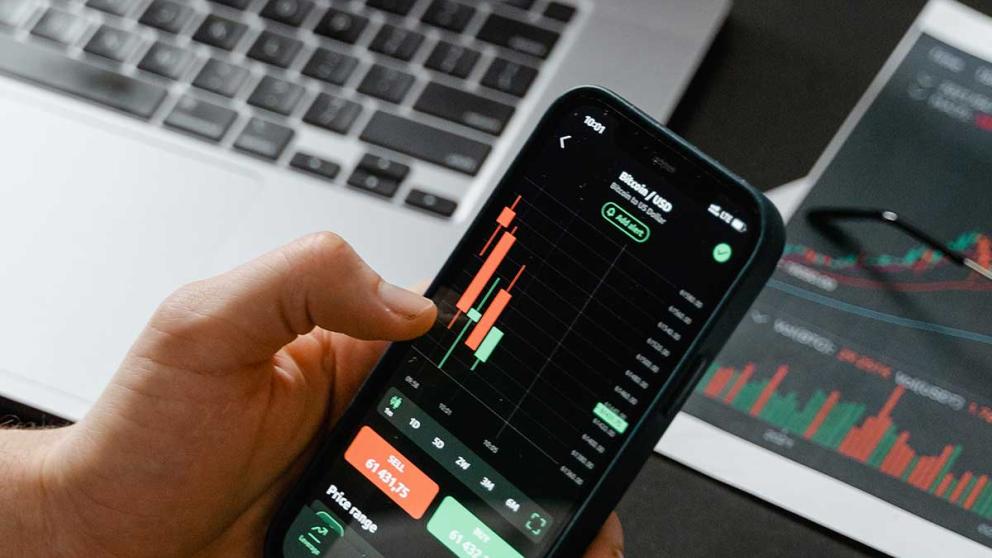 Person holding an iPhone with bitcoin stock trade on it