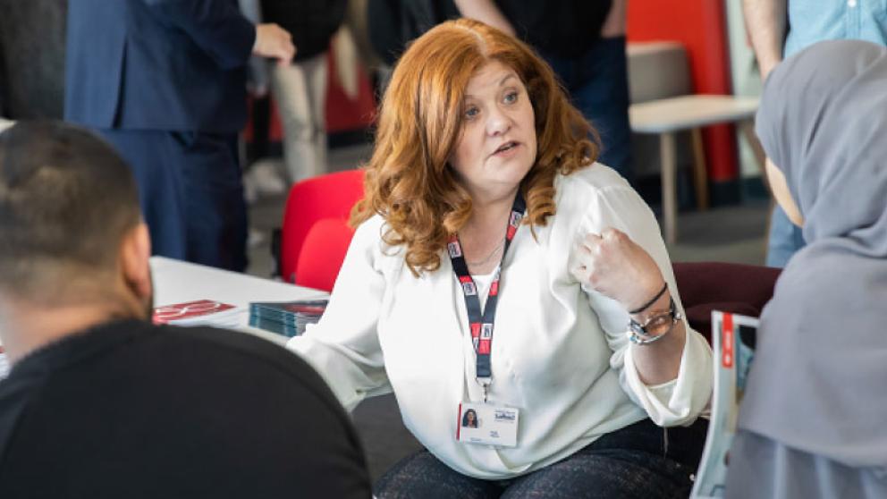 Staff and students in conversation in the Salford Business School