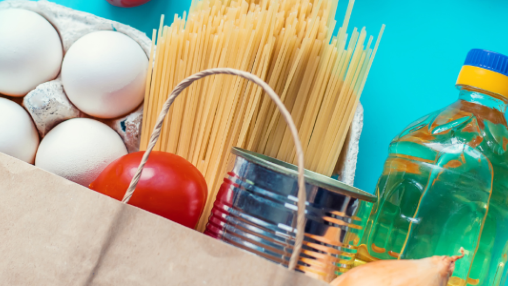 Onion, oil, pasta and eggs as part of a bag of groceries