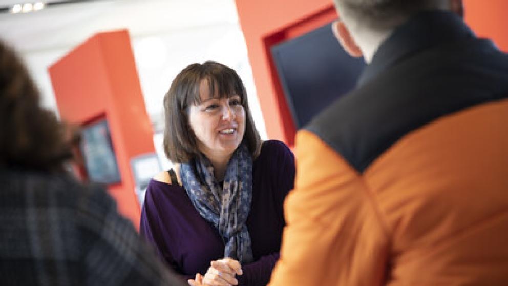 Staff member talking to two students