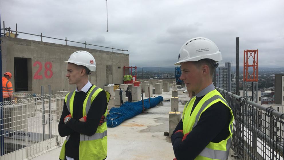 Surveying students stood on the roof of a new skyscraper in Manchester