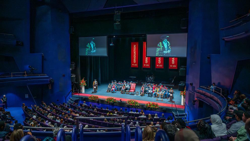 Seated guests watching the stage at a graduation ceremony inside the Lyric Theatre, The Lowry