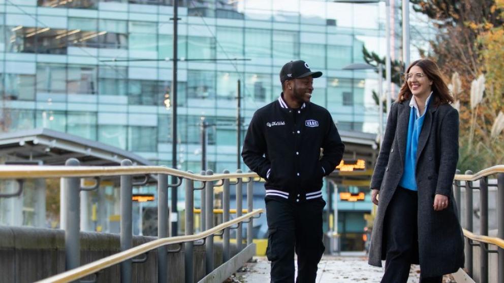 Rocio and Anthony walking down the tram platform at MediaCity