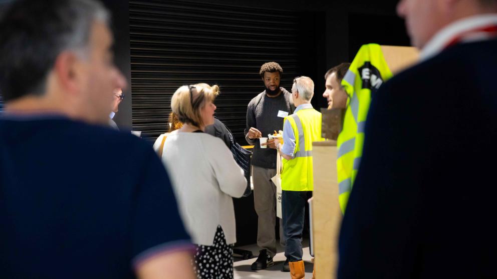 Employers networking in the SEE Building foyer, standing between Greater Manchester Construction Museum exhibits