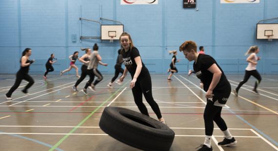 Students exercising in the University of Salford Sports Centre sports hall