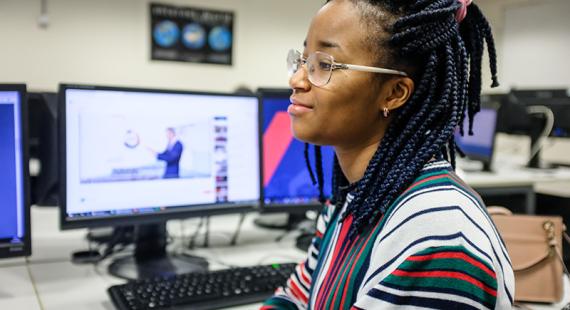 A student sitting beside a computer
