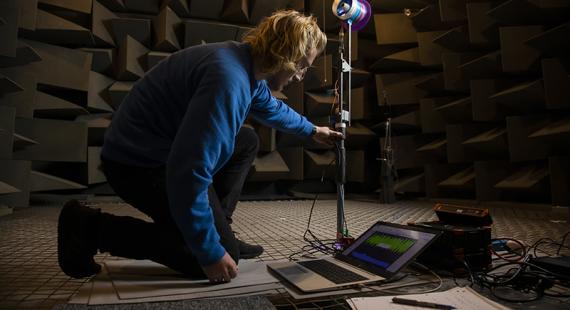 Student working on equipment in the anechoic chamber, Newton Building, University of Salford