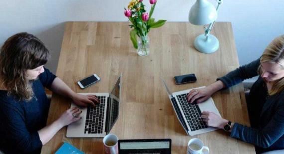 People work on laptops at a table