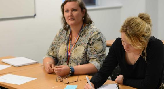 Two people sitting at a desk in a workshop
