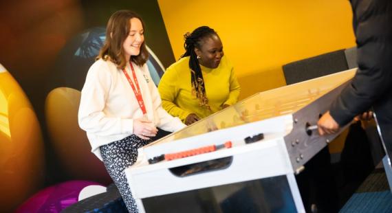 Students playing table football in Peel Park Quarter social area
