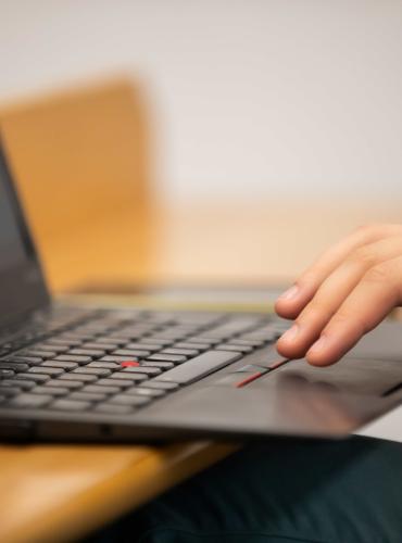 Hand typing on a laptop keyboard