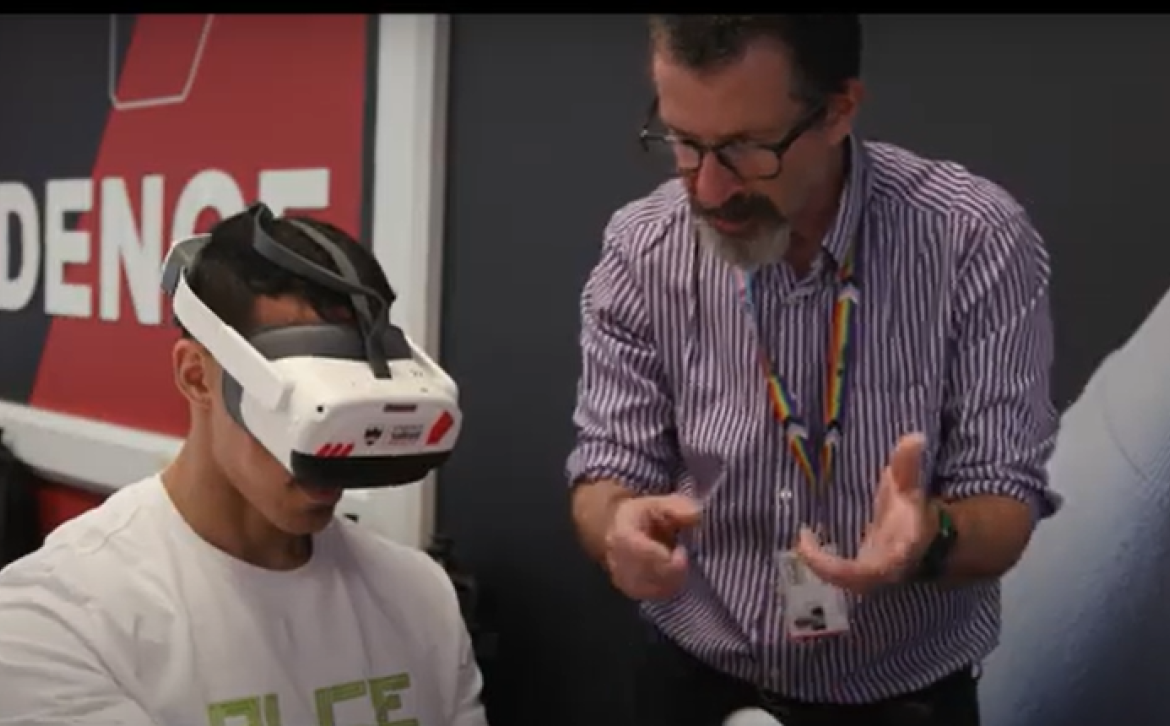 Lecturer talking to a student wearing a VR headset